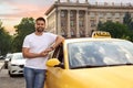 Handsome taxi driver near car on city street Royalty Free Stock Photo