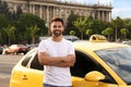 Handsome taxi driver near car on city street Royalty Free Stock Photo