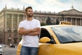 Handsome taxi driver near car on city street Royalty Free Stock Photo