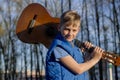 Handsome teen boy with guitar on the railway.