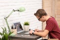 Handsome teenage boy doing homework at table Royalty Free Stock Photo