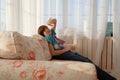 Handsome teenage boy sittin on a sofa and making faces