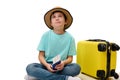 Handsome teenage boy traveler with boarding pass and suitcase, dreamily looking aside, traveling abroad for the weekend Royalty Free Stock Photo