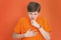 Handsome teenager boy coughing, suffering from illness such as a cold or the flu, feeling unwell and feverish