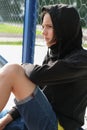 Handsome teenager boy sitting near net fence Royalty Free Stock Photo