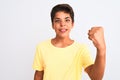 Handsome teenager boy standing over white isolated background angry and mad raising fist frustrated and furious while shouting