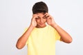 Handsome teenager boy standing over white isolated background with hand on head for pain in head because stress Royalty Free Stock Photo