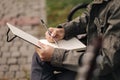 Handsome teenager painting something in his notepad outdood during the break. Talanted young boy Royalty Free Stock Photo