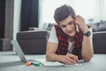 handsome teenager talking on smartphone while doing homework and lying Royalty Free Stock Photo