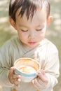 a handsome Thai baby boy holding coffee cup