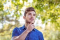 Handsome thinking hipster in the park