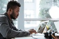 Handsome thinking serious young man sitting in office coworking