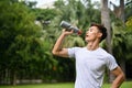 Handsome, thirsty and sweaty Asian athletic man in sportswear drinking water Royalty Free Stock Photo