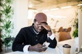 Handsome tired Afro American businessman in casual clothes while working with a laptop at home