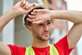 Handsome tired builder in a hardhat gazing into the distance Royalty Free Stock Photo