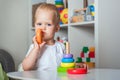 Handsome toddler plays with wooden toys in kindergarten or in children`s room close-up and copy space