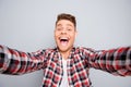 Handsome toothy comic man making selfie on gray background