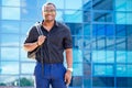 Handsome trendy African American university lecturer male with glasses in stylish clothes black shirt with a backpack on Royalty Free Stock Photo