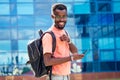 Handsome trendy African Americans nerd male with glasses in stylish clothes colorful T-shirt with a backpack on the Royalty Free Stock Photo