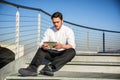 Handsome trendy man looking down at a tablet Royalty Free Stock Photo