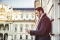 Handsome trendy man using cell phone to type text