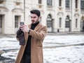 Handsome trendy man using cell phone in winter day Royalty Free Stock Photo