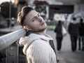 Handsome trendy young man, standing on a sidewalk in city