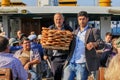 Handsome turkish man,bagel vender and his elderly partner selling delicious turkish bagels with sesame to ferry passengers