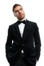 Handsome unshaved man in black tuxedo holding hands in pockets Royalty Free Stock Photo