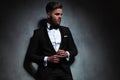 Handsome unshaved man wearing black tuxedo looks to side Royalty Free Stock Photo