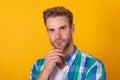 Handsome unshaven man portrait stroking chin with serious look yellow background, face Royalty Free Stock Photo