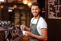 Handsome waiter adding milk to coffee