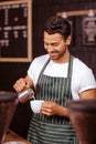 Handsome waiter adding milk to coffee