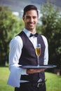 Handsome waiter holding a tray with glass of champagne Royalty Free Stock Photo