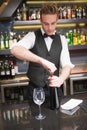 Handsome waiter opening a bottle of red wine Royalty Free Stock Photo