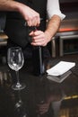 Handsome waiter opening a bottle of red wine Royalty Free Stock Photo
