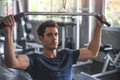 Handsome weightlifter lifting barbells working out in the gym