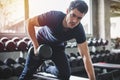 Handsome weightlifter lifting bench press working out with dumbbell in the gym