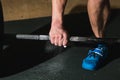 Handsome weightlifter preparing for training with barbell