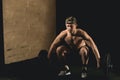 Handsome weightlifter preparing for training with barbell