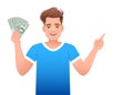 A handsome white man in a blue T-shirt with money in his hand. The young man holds dollar bills in his hand and points with his