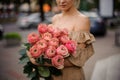 Handsome woman holds lovely bouquet of stylish bright peony roses Royalty Free Stock Photo