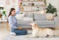 Handsome woman playing with dog in living room Royalty Free Stock Photo