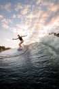 Handsome woman rides down on surf style wakeboard on splashed river wave Royalty Free Stock Photo