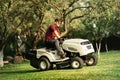 Handsome worker using ride-on tractor lawn mower Royalty Free Stock Photo