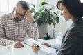 Worried man sitting at a desk in front of his professional therapist