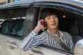 A handsome young-adult Asian man in casual outfit is talking on the phone while driving a car Royalty Free Stock Photo