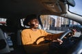 Handsome young African American man in his new high-tech electric vehicle while drinking. Self driving vehicle concept Royalty Free Stock Photo