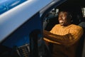 Handsome young African American man in his new high-tech electric vehicle while drinking. Self driving vehicle concept Royalty Free Stock Photo