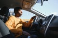 Handsome young African American man in his new high-tech electric vehicle while drinking. Self driving vehicle concept Royalty Free Stock Photo